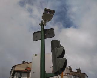 Composición abstracta de elementos del mobiliario urbano de señales, cámara y semáforo.